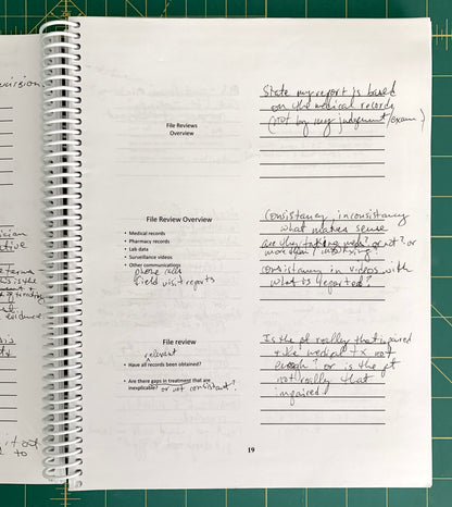 A spiral-bound notebook page with handwritten notes and printed text, photographed from above on a green cutting mat background.
[additional_image_link]