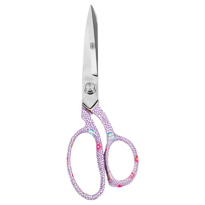 A pair of scissors with silver metal blades and handles decorated with a dense pattern of small pink, purple, and white flowers, isolated on a white background.
Photo by Kaffe Fassett [additional_image_link]