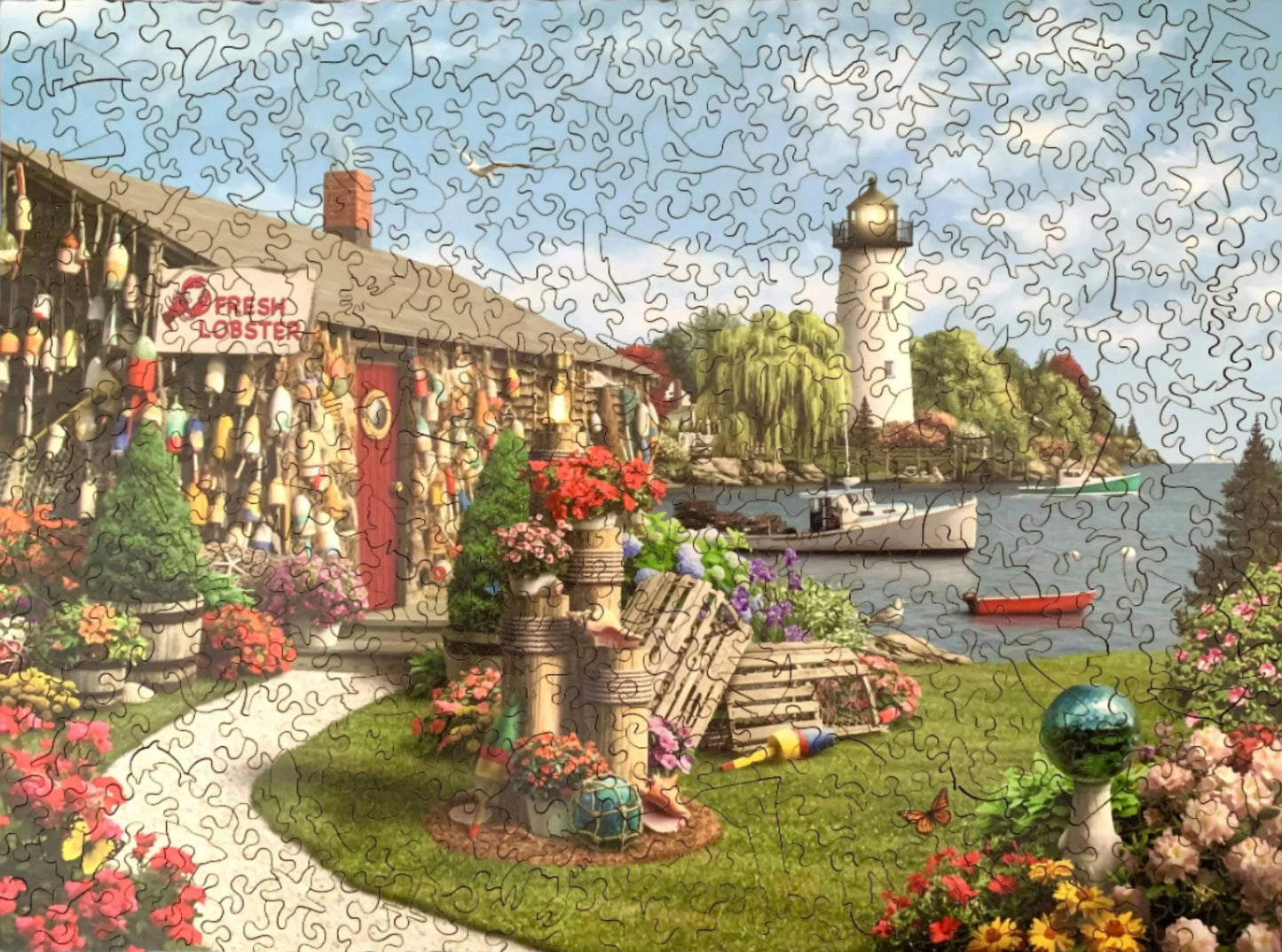 A completed jigsaw puzzle depicting a vibrant and colorful lobster cove scene with a lighthouse, buoys, and a fresh lobster sign.
Photo by Karen King [additional_image_link]