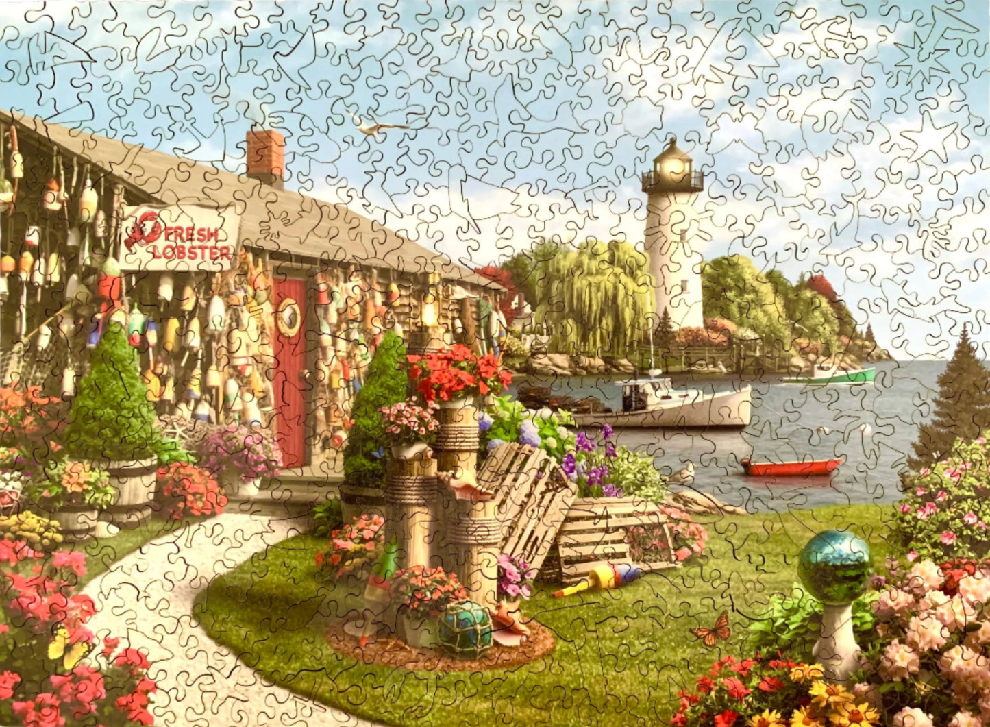 A completed jigsaw puzzle depicting a vibrant and colorful lobster cove scene with a lighthouse, buoys, and a fresh lobster sign.
Photo by Karen King [additional_image_link]