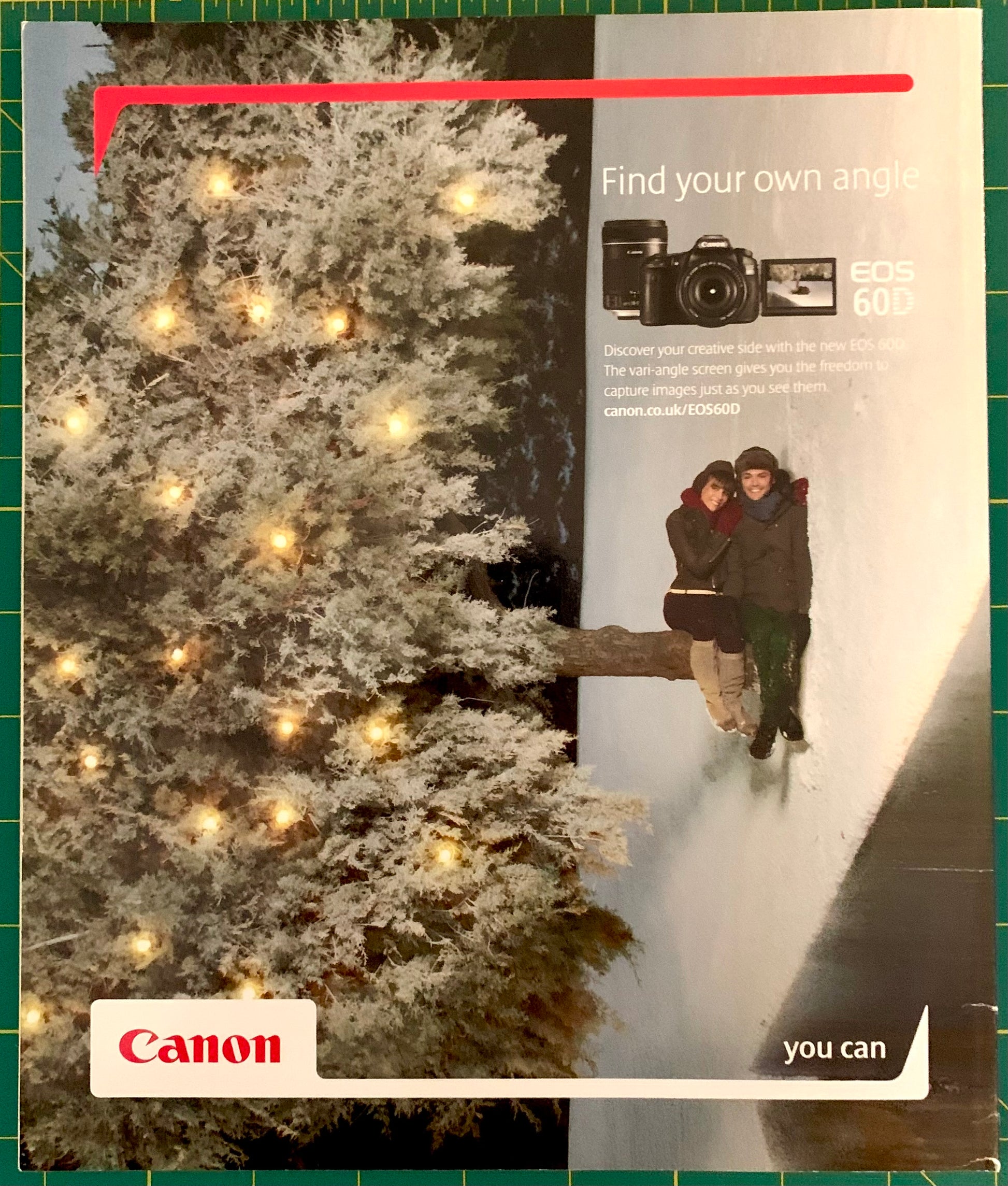 A Canon EOS 60D camera advertisement featuring a snowy Christmas tree with warm lights on the left and a couple snowboarding on the right, with the Canon logo at the bottom left.
[additional_image_link]
