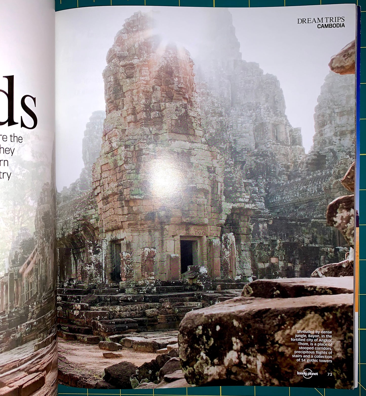 A printed travel magazine or book spread showing a large photograph of ancient stone ruins in Cambodia, with the headline 'DREAM TRIPS CAMBODIA' and a small Lonely Planet logo at the bottom.
[additional_image_link]