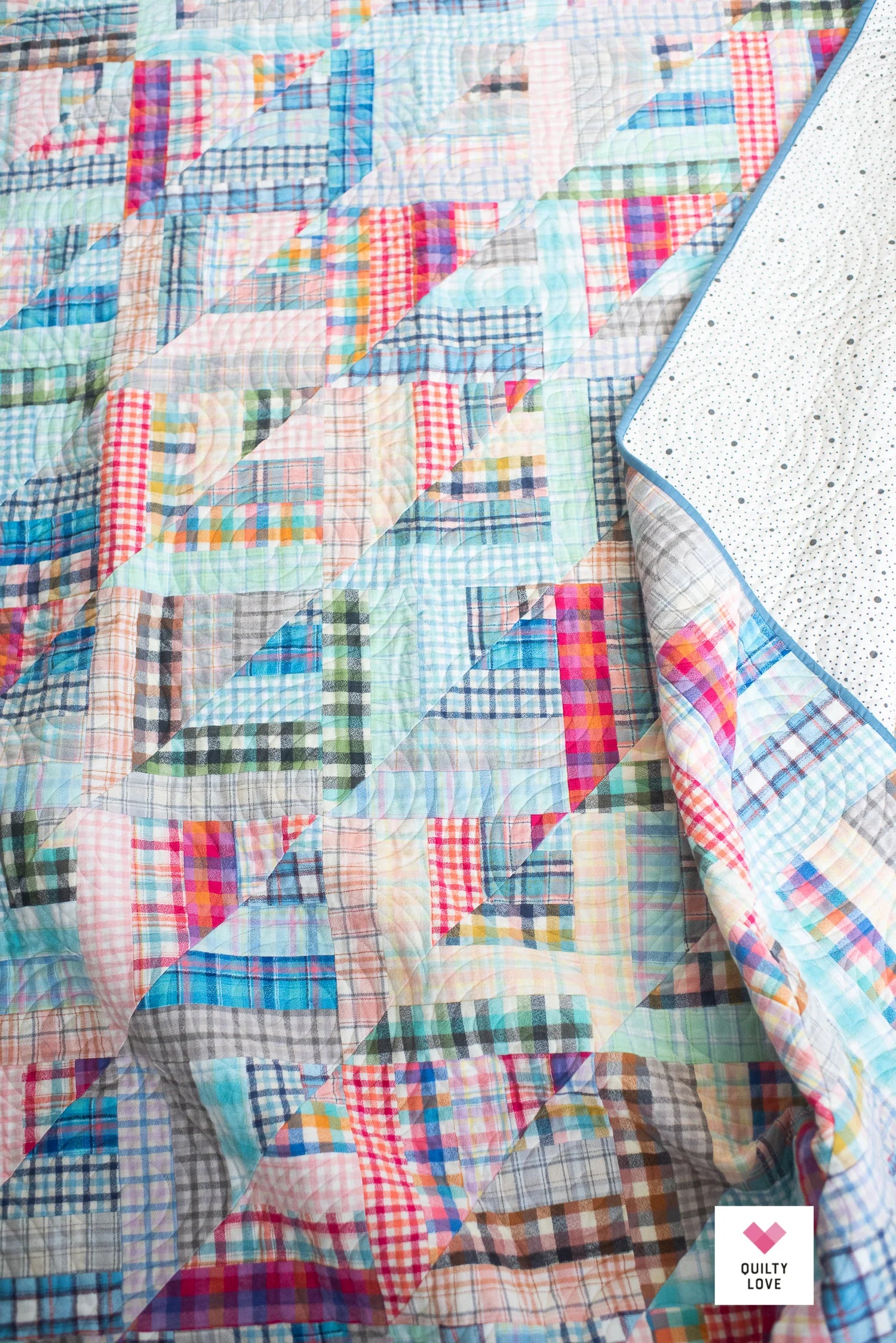 Colorful patchwork quilt with geometric patterns on a textured surface.
Photo by Quilty Love [additional_image_link]