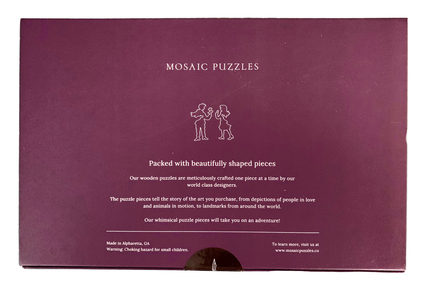 The back of a purple Mosaic Puzzles gift box, showing product description text and a small line drawing of two children assembling a puzzle.
Photo by Karen King [additional_image_link]