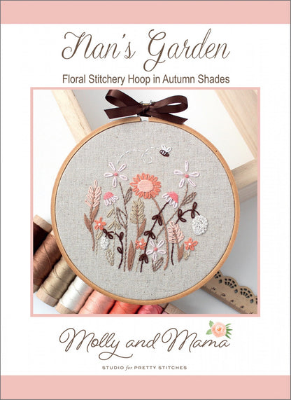 Cover of a floral stitchery hoop pattern titled 'Nan's Garden' by Molly and Mama Studio for Pretty Stitches, featuring a circular embroidery hoop with a floral design in autumn shades on a linen fabric background.
Photo by Molly and Mama [image_link]