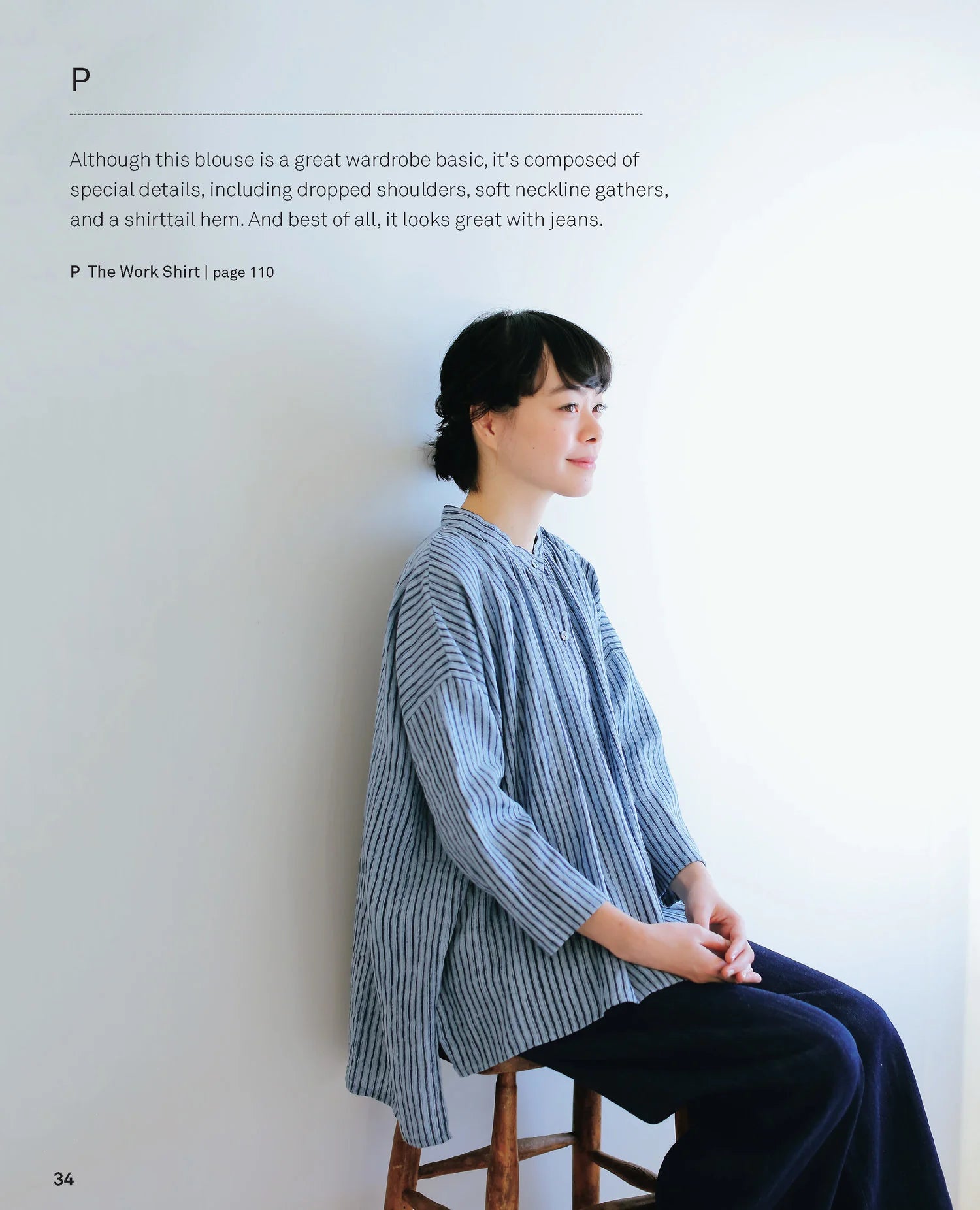 Person wearing a blue striped blouse sitting on a stool against a white wall.
[additional_image_link]