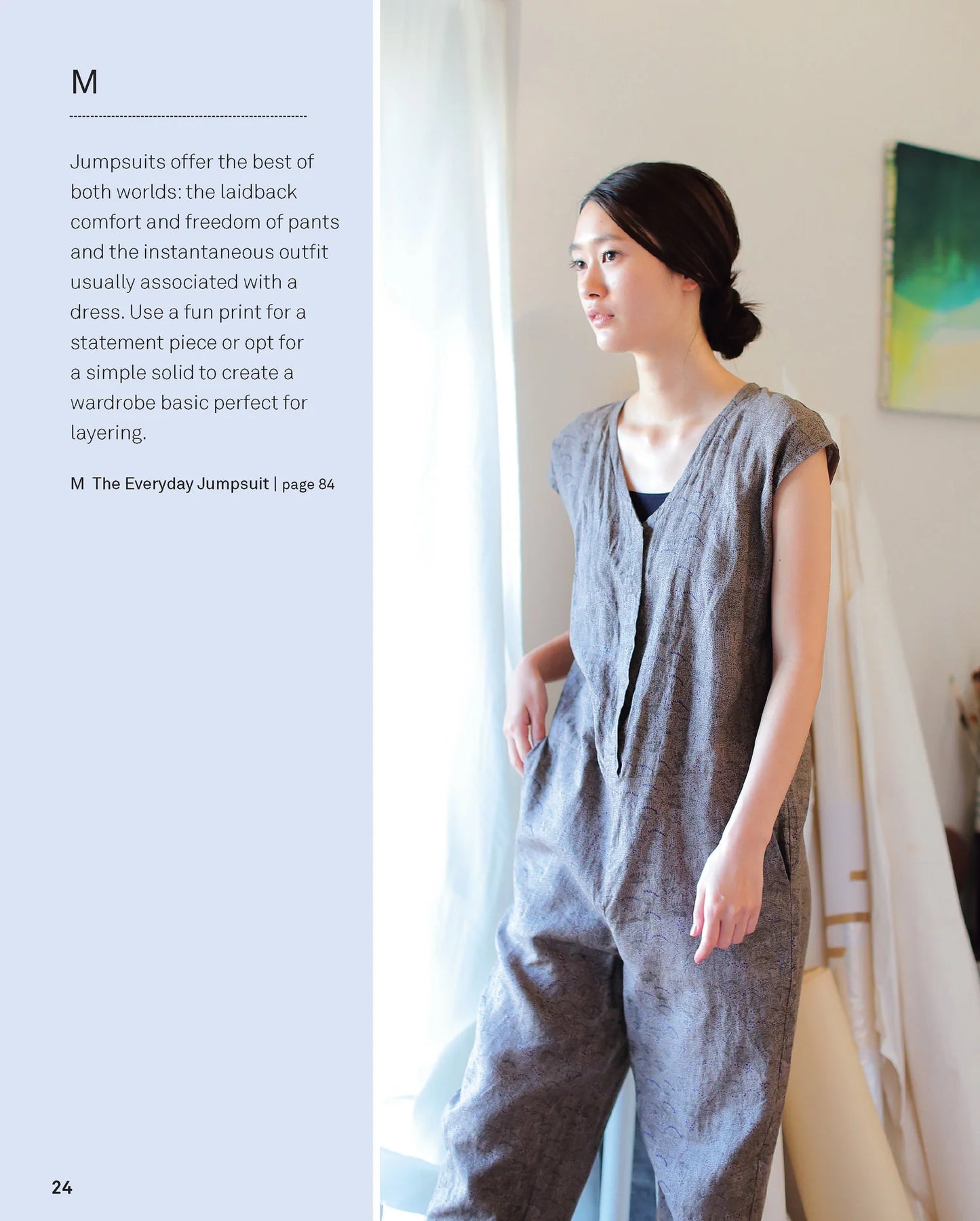 Woman wearing a gray jumpsuit in a room with a painting on the wall.
[additional_image_link]
