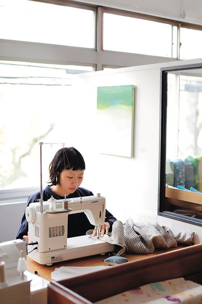 Person using a sewing machine in a bright room with large windows.
[additional_image_link]