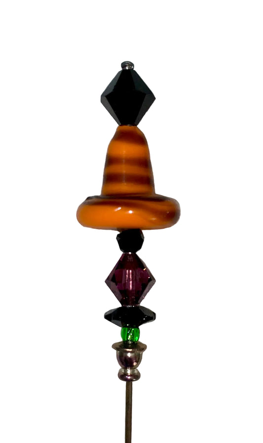 Decorative orange witch hat stick pin with green and purple beads on a white background.
[image_link]