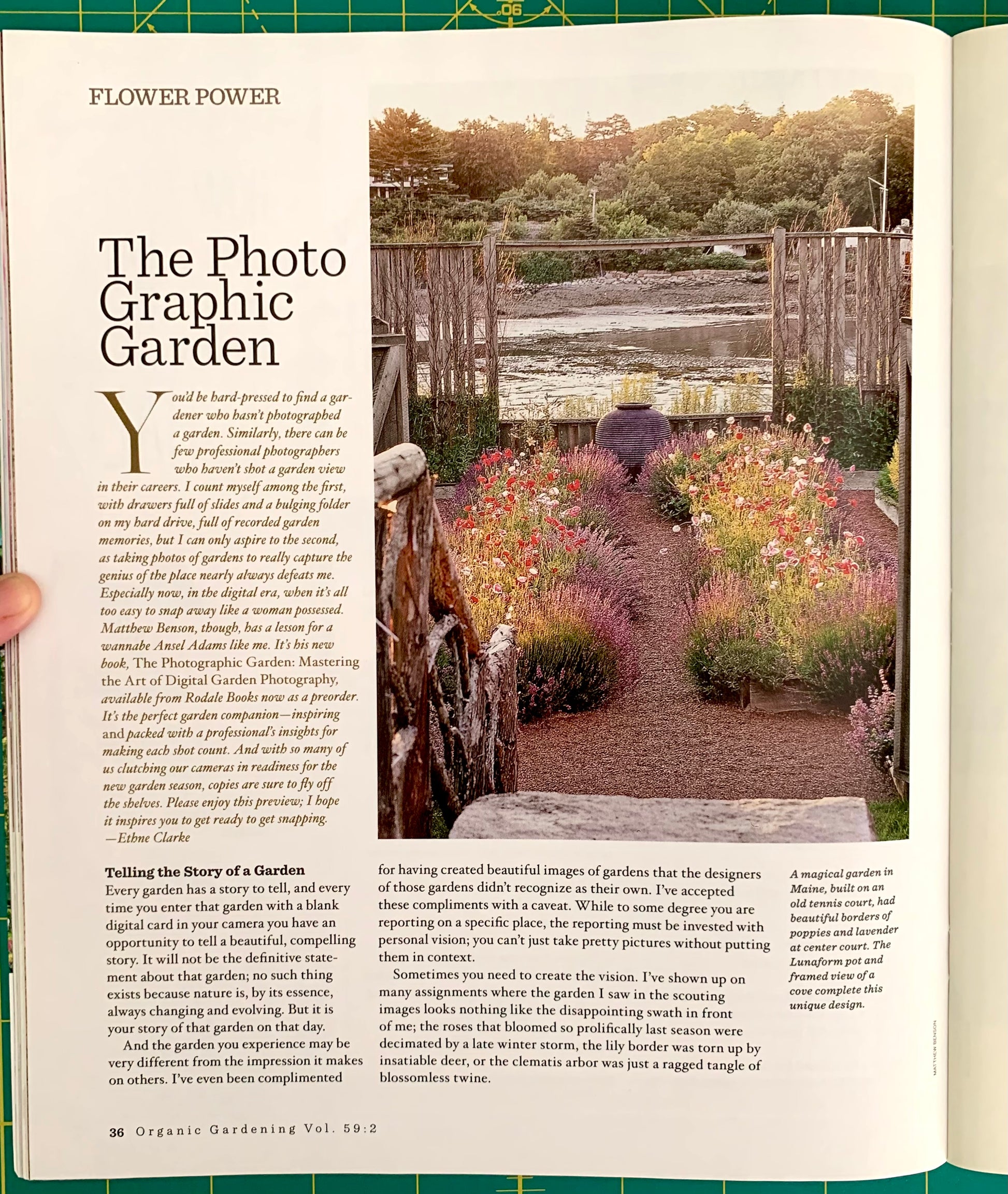 A printed magazine or book spread showing an article titled "The Photo Graphic Garden" with a large photo of a garden bed and columns of text. The page is photographed against a green background.
[additional_image_link]