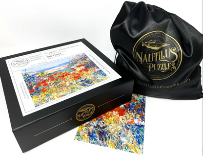 A jigsaw puzzle depicting a vibrant summer scene with red poppies and green foliage, based on the artwork 'Poppies, Isles of Shoals, Maine' by Childe Hassam.
Photo by Nautilus Puzzles [additional_image_link]