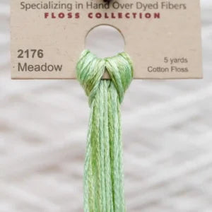 Meadow green embroidery floss on a cardboard holder with product details.