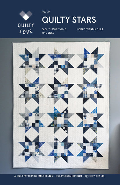 A quilt pattern cover for 'Quilty Stars' by Emily Dennis, showing a completed quilt with a geometric star and diamond patchwork design in shades of blue, navy, white, and gray. The top header is navy blue with white text.
Photo by Quilty Love [image_link]