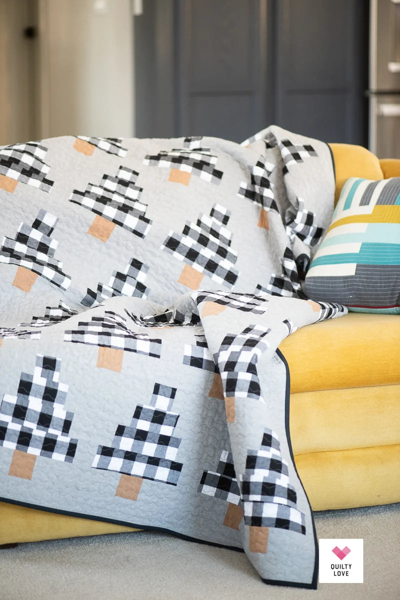 Patterned quilt draped over a yellow sofa with a neutral background.
Photo by Quilty Love [additional_image_link]