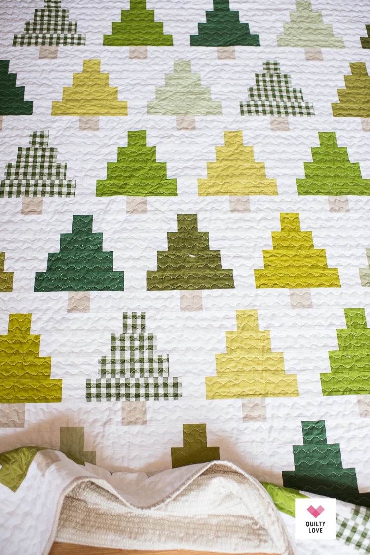 Quilt with green and yellow geometric pattern on a white background.
Photo by Quilty Love [additional_image_link]