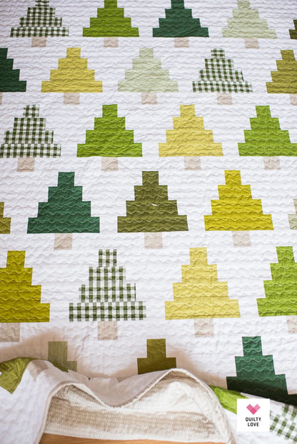 Quilt with green and yellow geometric pattern on a white background.
Photo by Quilty Love [additional_image_link]