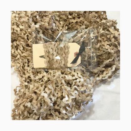 A close-up of a beige and brown ric rac, with a small clear plastic bag containing a beige label placed on top.
Photo by Hands on Design [additional_image_link]