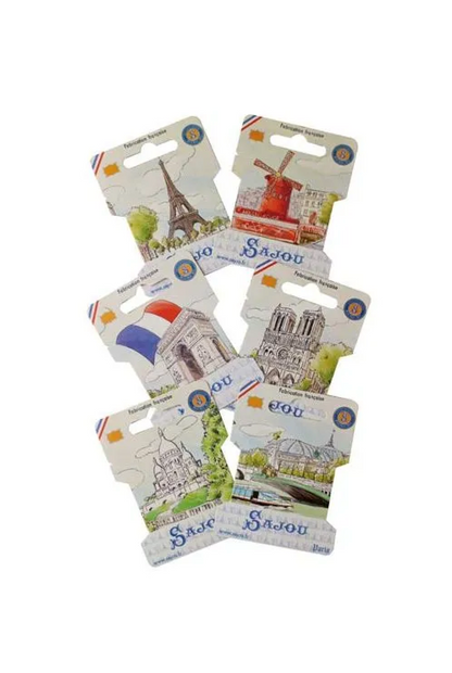 Six small souvenir Ribbon Cards featuring French landmarks and scenes, including the Eiffel Tower, a windmill, Notre Dame, and a bridge, arranged on a plain white background.
Photo by Sajou.fr [image_link]