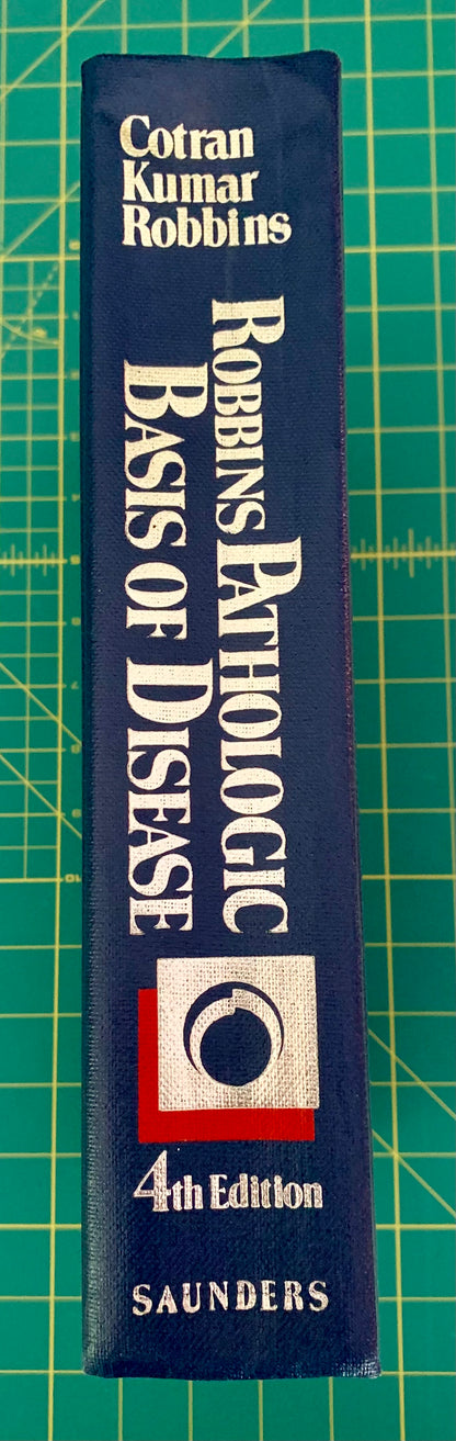 A single book standing upright on a green cutting mat. The book cover is dark blue with large white text reading 'Robbins Pathologic Basis of Disease' and '4th Edition,' plus the Saunders publisher mark near the bottom.
[additional_image_link]