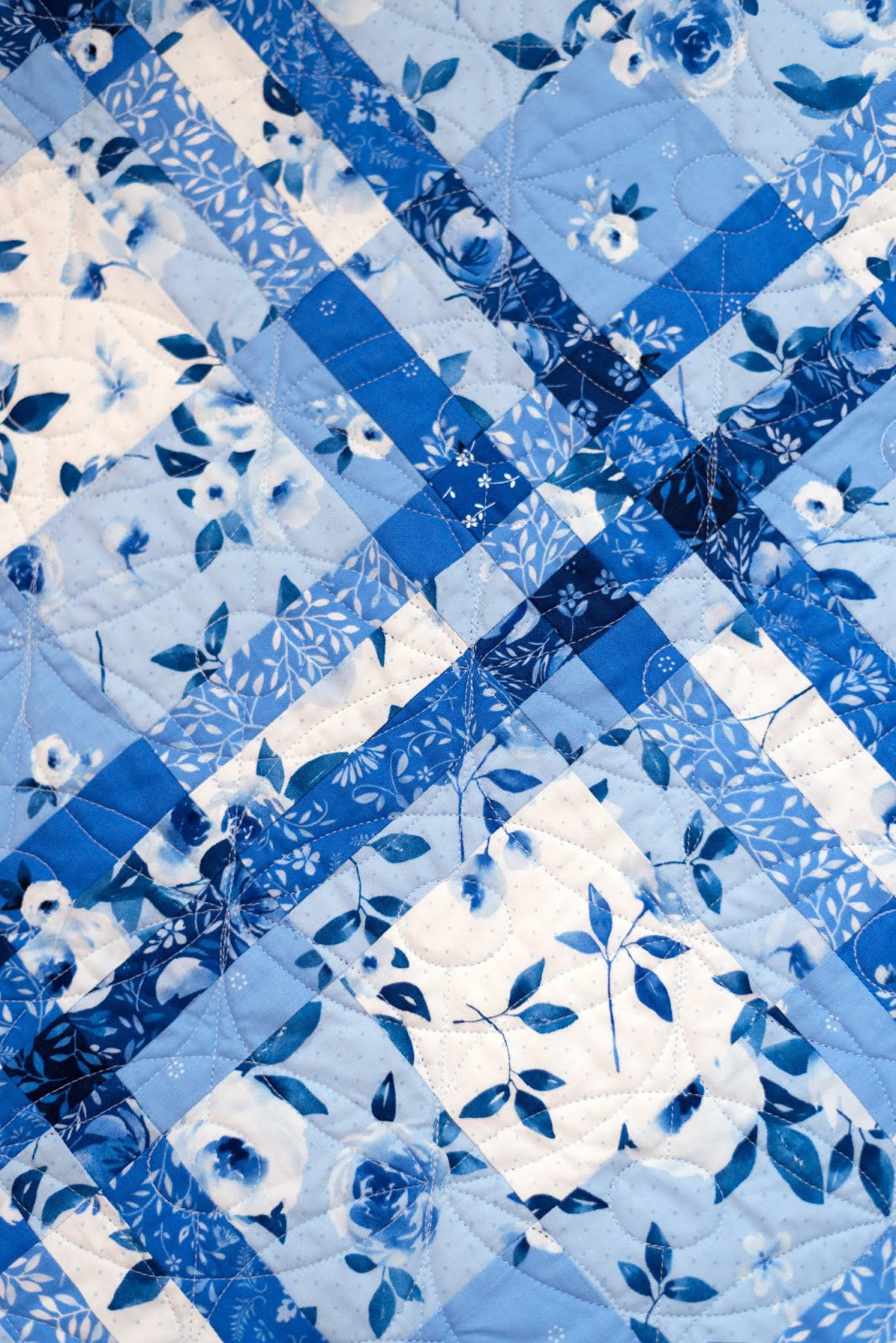 A quilt featuring a blue and white geometric pattern resembling a woven shawl.
Photo by Briar Hill Designs [additional_image_link]