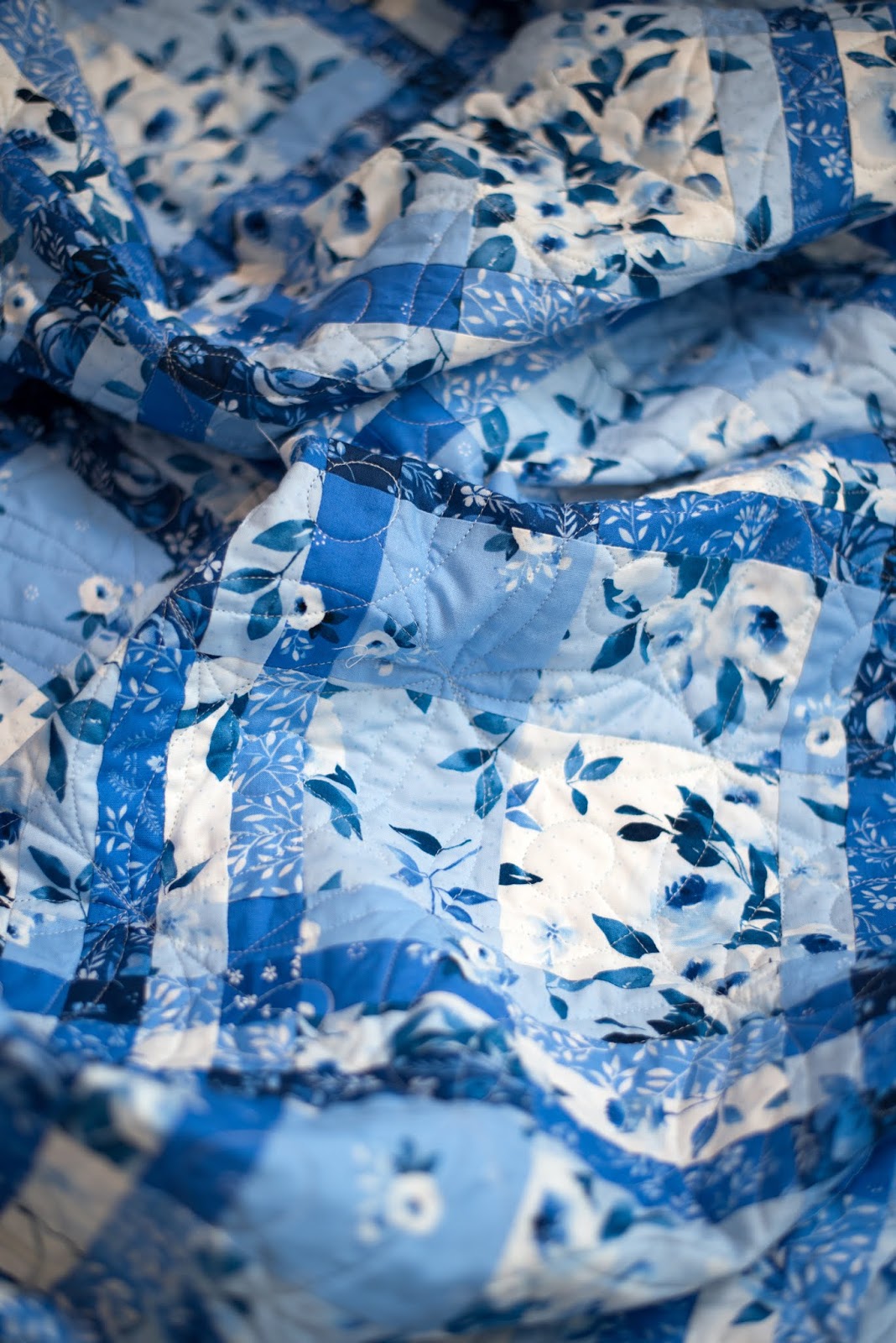 A quilt featuring a blue and white geometric pattern resembling a woven shawl.
Photo by Briar Hill Designs [additional_image_link]