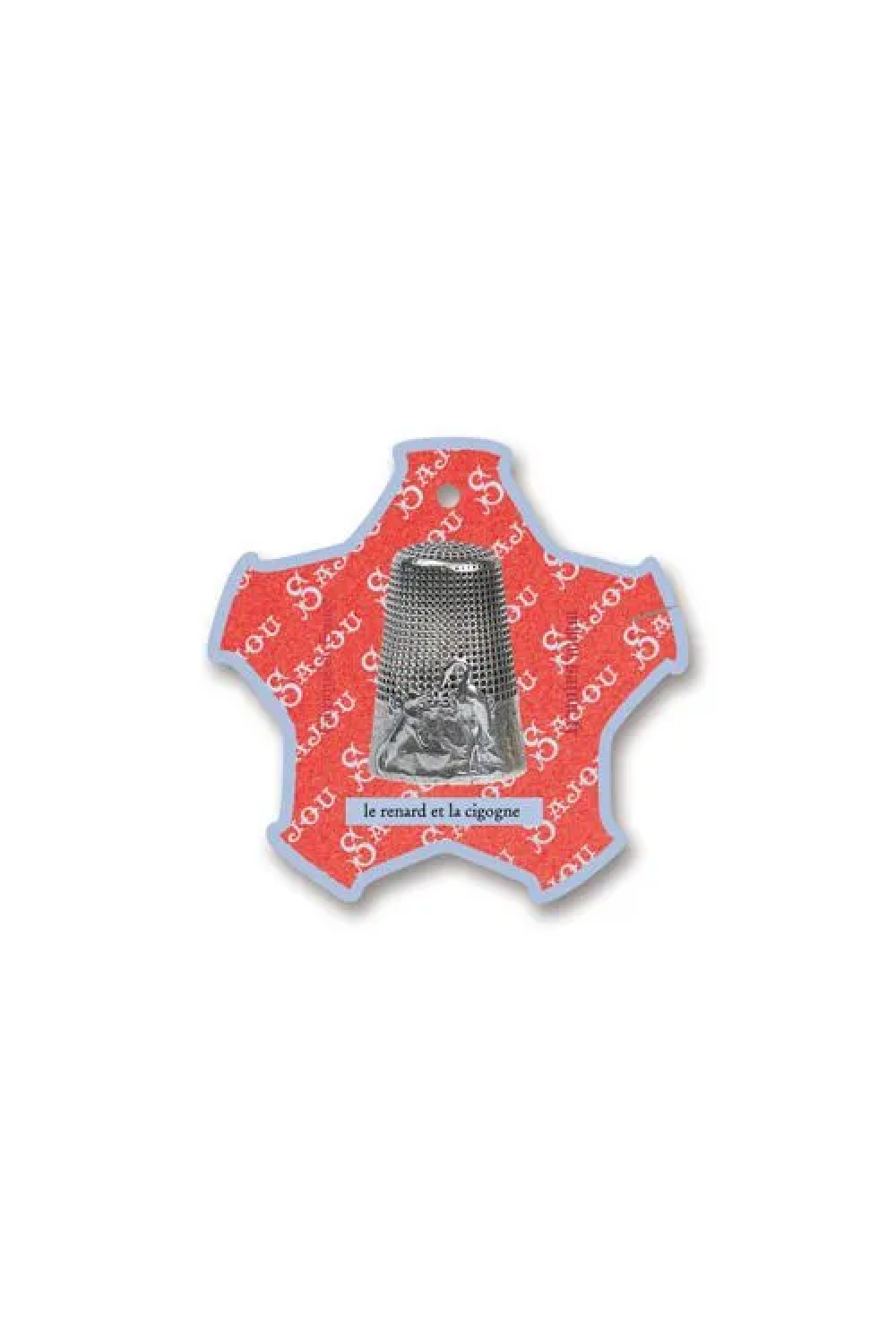 A vintage-style Saint Anthony thread card with a silver-toned metal figure inside a star-shaped glass cover, set against a white fabric background.
Photo by Sajou.fr [additional_image_link]