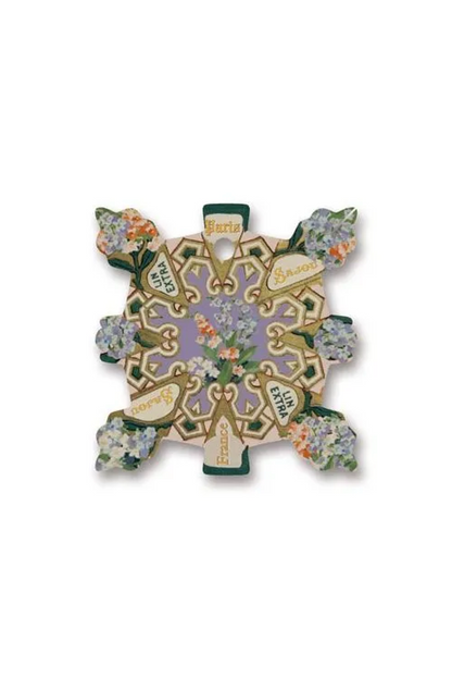 An ornate square decorative thread card featuring a lavender and gold baroque-style filigree center with floral accents in green, white, and gold, set against a plain white background.
Photo by Sajou.fr [additional_image_link]