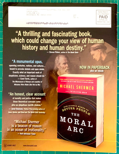 A book advertisement for Michael Shermer's 'The Moral Arc' showing a paperback and a larger box/book cover, with large review quotes and a dark background. The ad is photographed on a green cutting mat.
[additional_image_link]