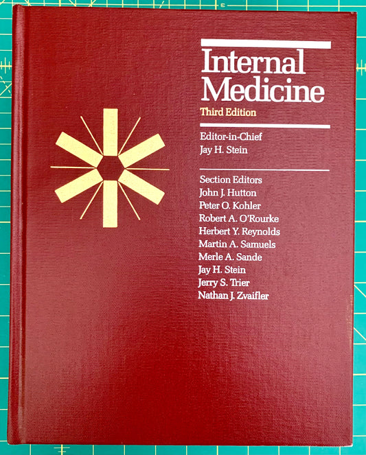 A hardcover book titled 'Internal Medicine Third Edition' with a dark red cover, white text, and a gold starburst emblem, photographed on a green cutting mat background.
[image_link]