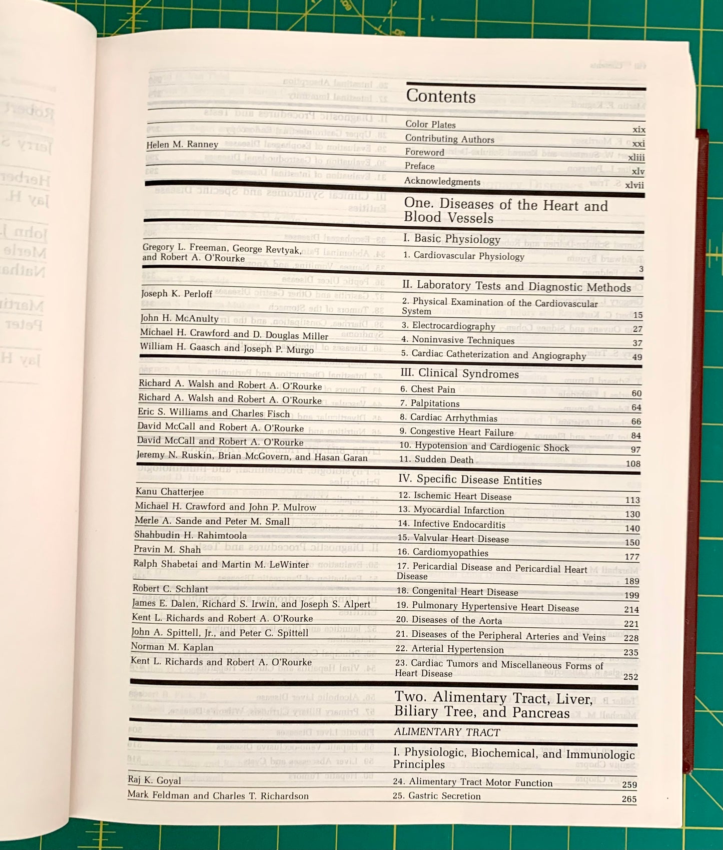 An open book showing the contents page for 'One Diseases of the Heart and Blood Vessels' with a table of contents printed in black text on white pages, photographed against a green cutting mat.
[additional_image_link]