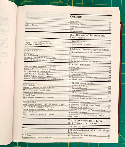 An open book showing the contents page for 'One Diseases of the Heart and Blood Vessels' with a table of contents printed in black text on white pages, photographed against a green cutting mat.
[additional_image_link]