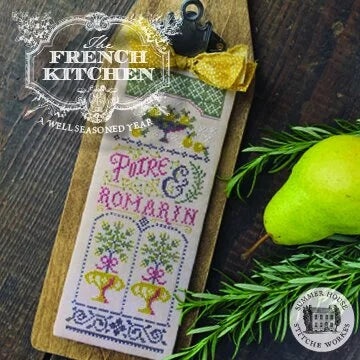 A decorative embroidered cross-stitch sampler card reading 'Pitre & Romarin' with floral and architectural motifs, displayed on a wooden board with a pear, rosemary, and a tea bag nearby. The image includes branding overlays for 'The French Kitchen' and 'Poire & Romarin'.
Photo by HandsOnDesign.biz [additional_image_link]