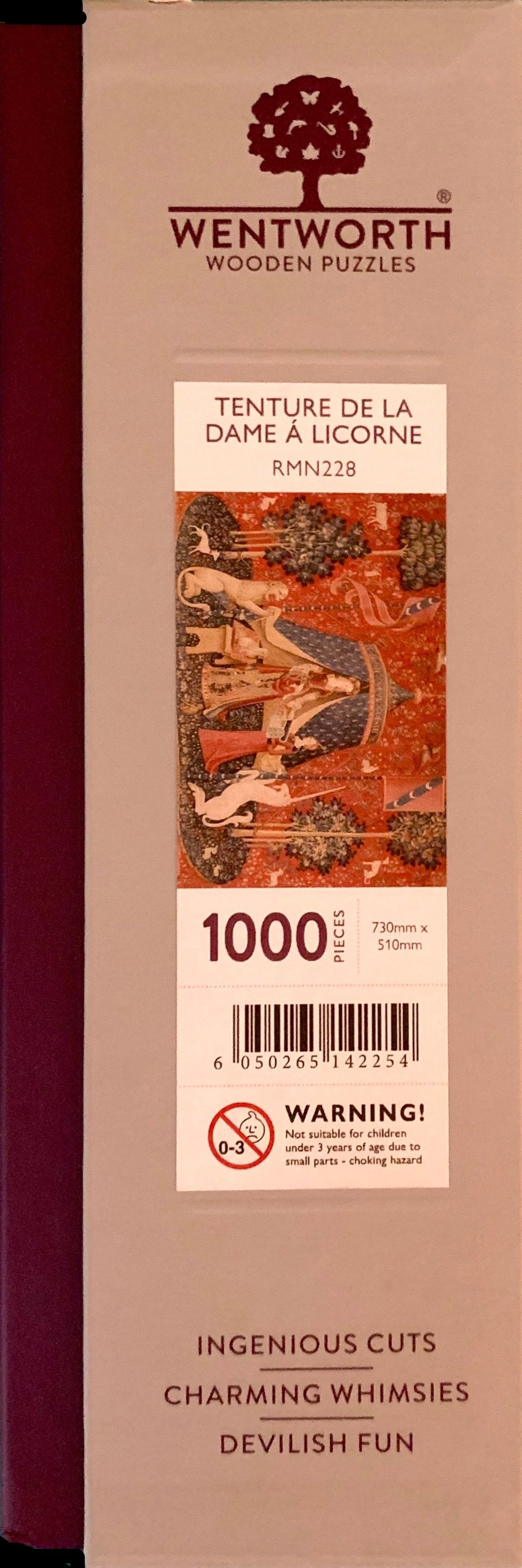 A completed wooden jigsaw puzzle depicting a medieval-style tapestry scene with a figure, animals, and decorative elements in red, blue, and natural wood colors.
Photo by Karen King [additional_image_link]