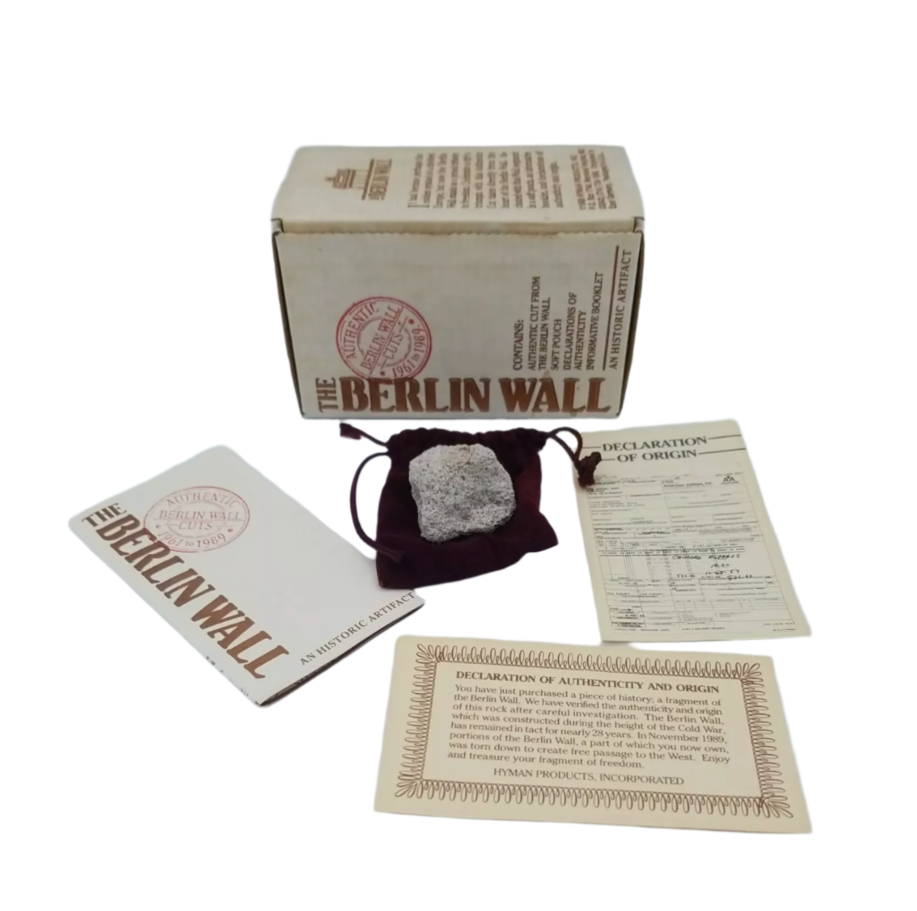 Collection of Berlin Wall-themed items including a stone, box, and cards on a gray background
[additional_image_link]