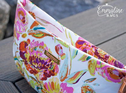 Colorful floral-patterned bag on a wooden surface with 'Emmaline Bags' branding.
Photo by Emmaline Bags [additional_image_link]