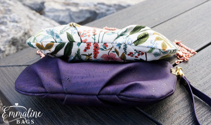 Floral-patterned pouch on a purple clutch on a wooden surface.
Photo by Emmaline Bags [additional_image_link]