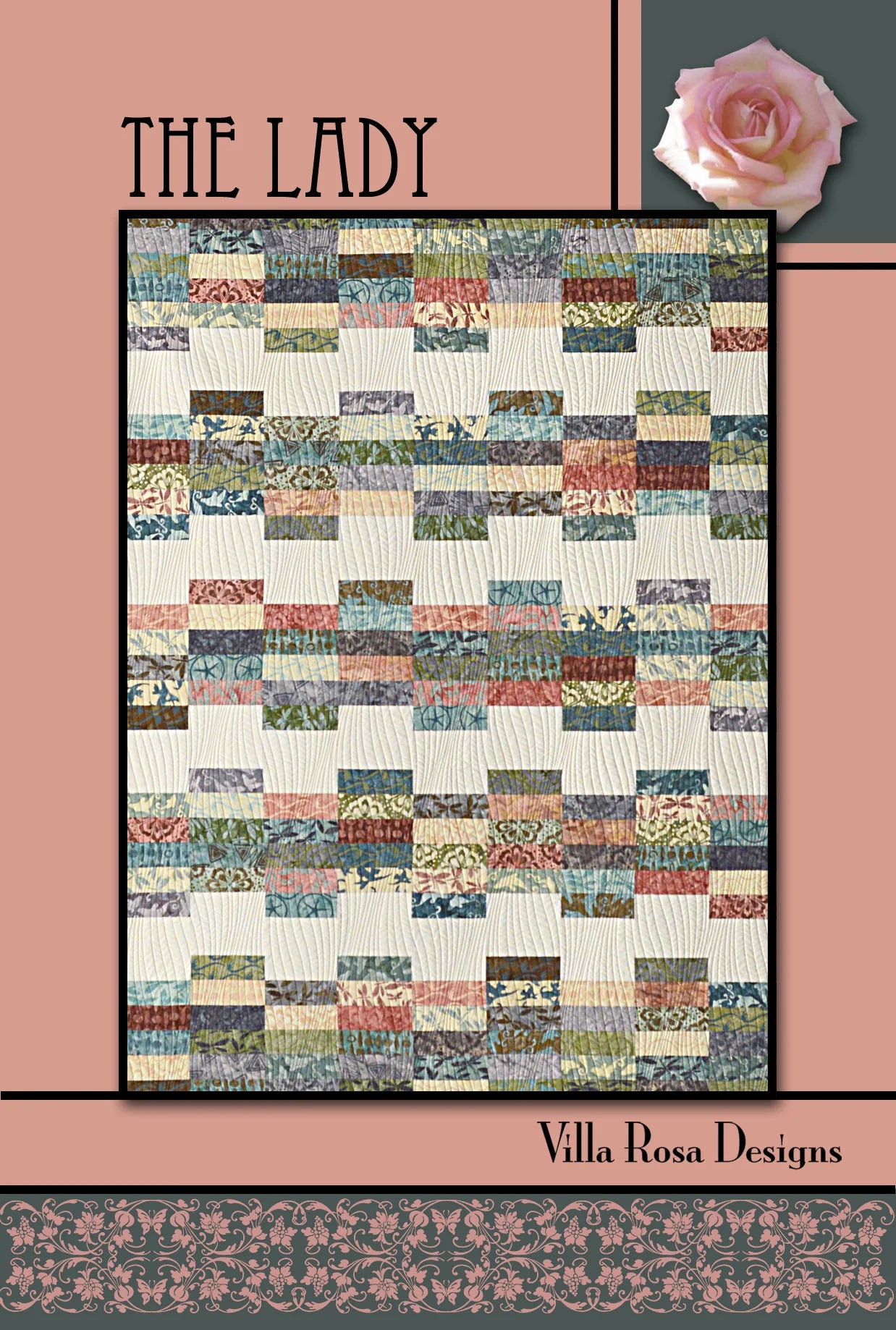 A quilt pattern cover titled 'THE LADY' by Villa Rosa Designs, featuring a patchwork quilt design with a cream background and multicolored rectangular fabric blocks, framed by a dusty pink border with a rose illustration in the top right.
Photo by Villa Rosa Designs [image_link]