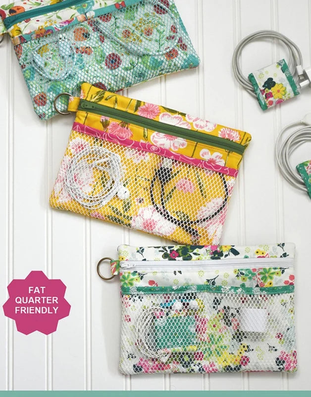 Three fabric zip pouches with mesh front pockets are arranged on a white paneled background. The pouches have floral prints in green, yellow, and white, with some shown containing charging cables.
Photo by Around the Bobbin [additional_image_link]