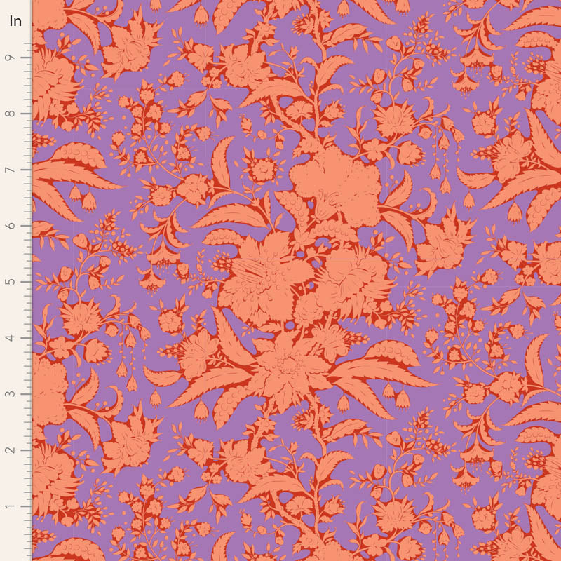 A close-up of a floral fabric pattern with coral-orange flowers and leaves on a lavender-purple background, shown with a white ruler along the left edge for scale.
Photo by Tildafabrics.com [image_link]