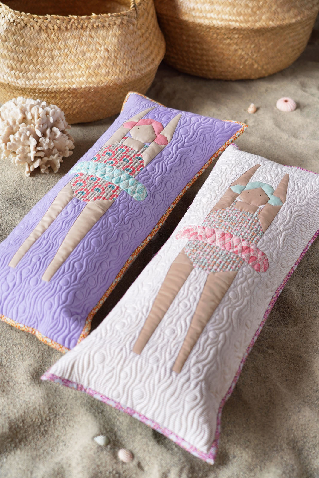 Two quilted pillows with swimmer designs on a sandy surface.
Photo by Tildafabrics.com [image_link]
