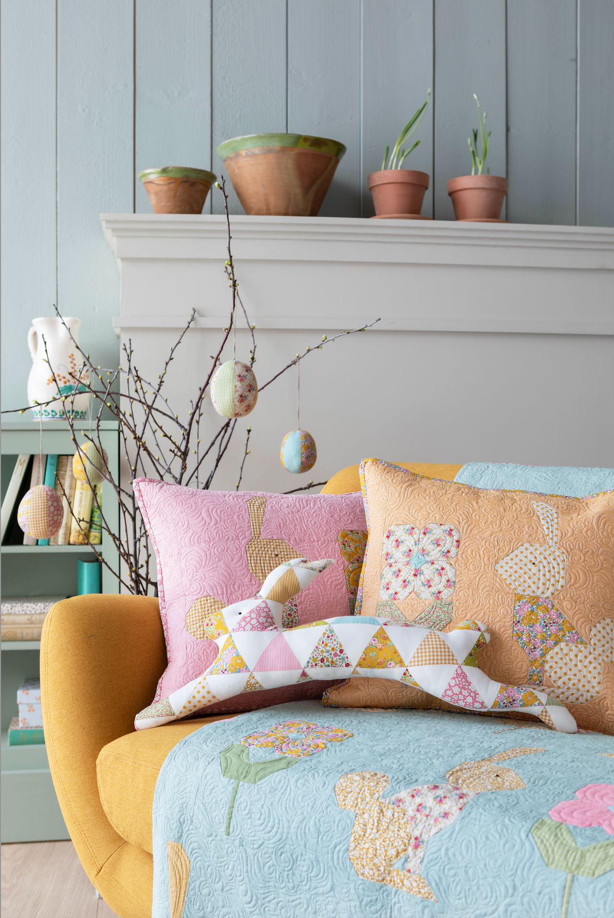 Decorative pillows and quilt on a yellow chair against a gray wall with plants.
Photo by Tildafabrics.com [additional_image_link]