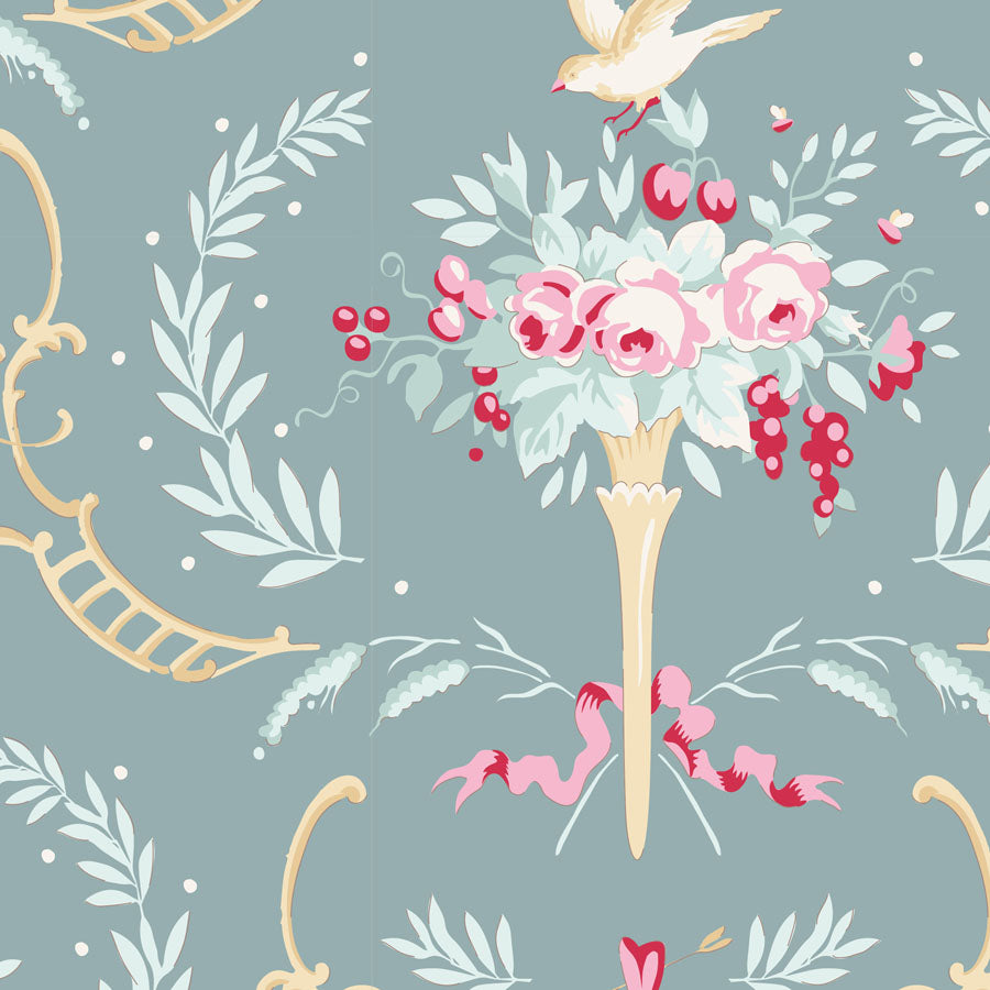 A repeating decorative pattern featuring pink and white flowers in a vase with red berries, pale green leaves, gold scroll motifs, and a small bird on a muted blue-gray background.
Photo by Tildafabrics.com [image_link]