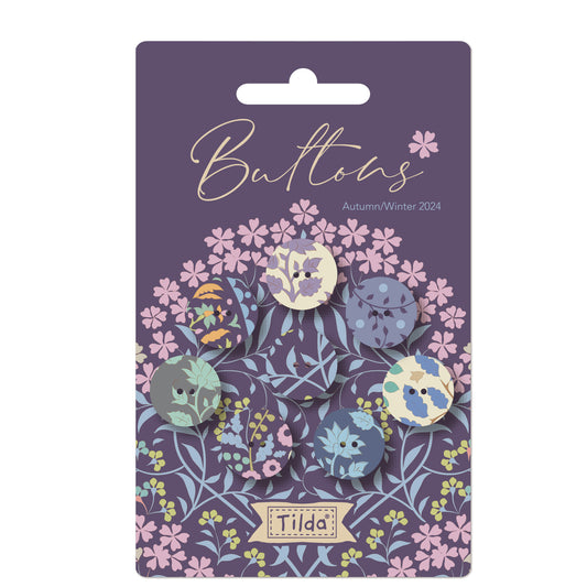 Pack of Tilda Sanctuary fabric covered buttons in various shades of blue, featuring floral and geometric patterns.
Photo by Tildafabrics.com [image_link]