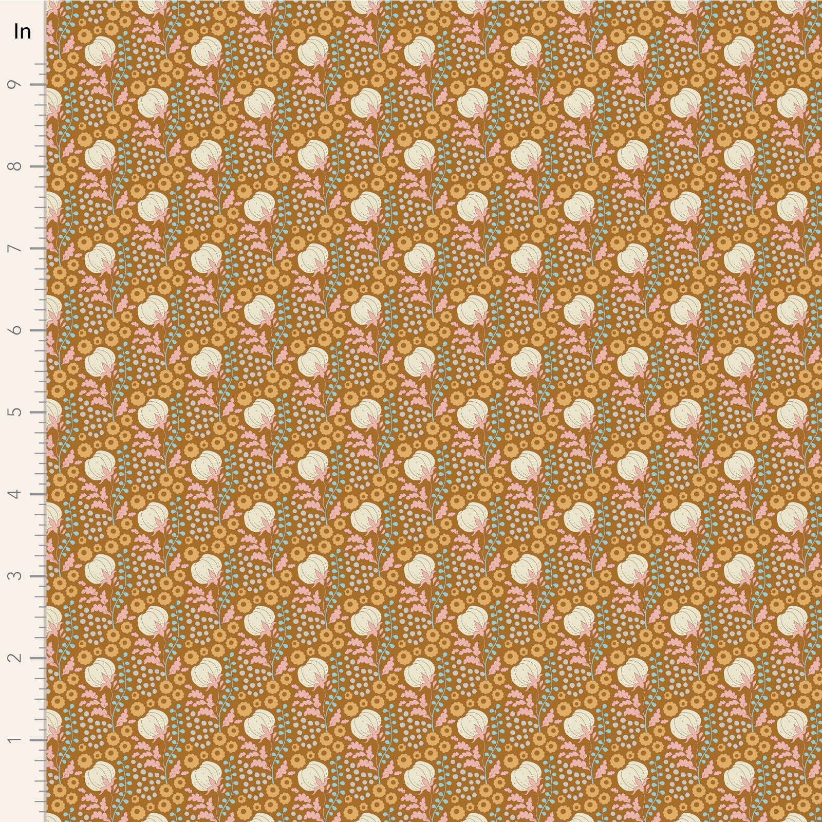 A close-up of a patterned fabric sample with a repeating floral design on a warm mustard background. The pattern includes cream flowers, pink leaves, and small blue-green dots, with a white measurement ruler along the left edge marked in inches.
Photo by Tildafabrics.com [image_link]
