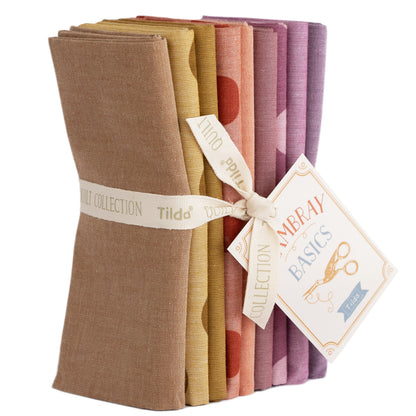 A bundle of Tilda Seasonal Chambray Basics Autumn Hues fat quarters, featuring a variety of woven fabrics in shades of brown, beige, and purple, tied together with a ribbon.
Photo by Tildafabrics.com [image_link]