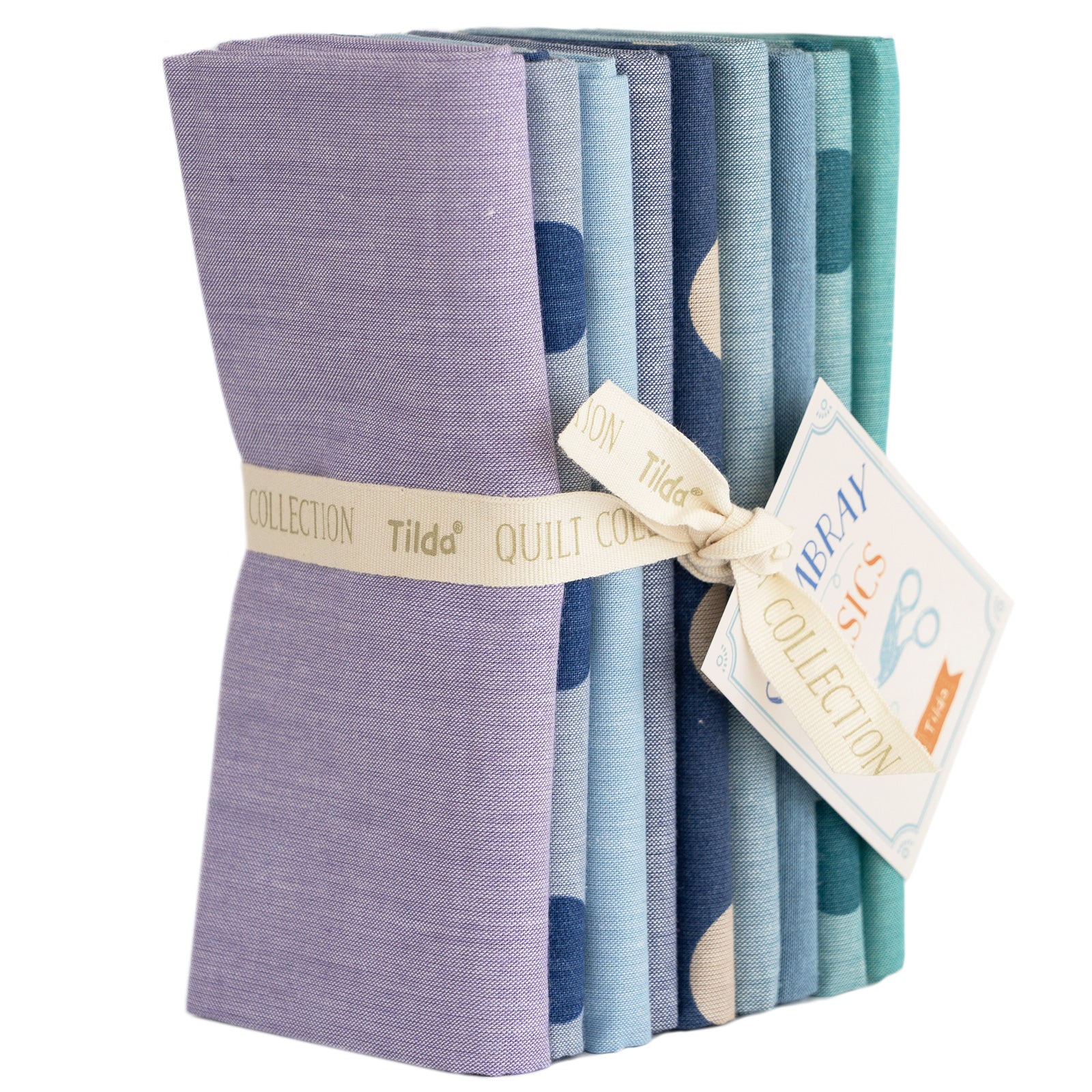 A bundle of folded woven fabrics in various summer blue colors, tied together with a label that reads 'Tilda Quilt Collection'.
Photo by Tildafabrics.com [image_link]