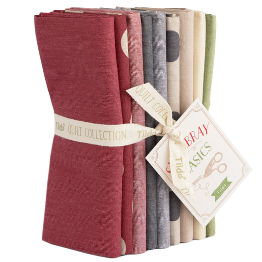 A stack of Tilda Seasonal Chambray Basics Winter Hues fat quarters in red, gray, and green, tied together with a label showing the brand and product name.
Photo by Tildafabrics.com [image_link]