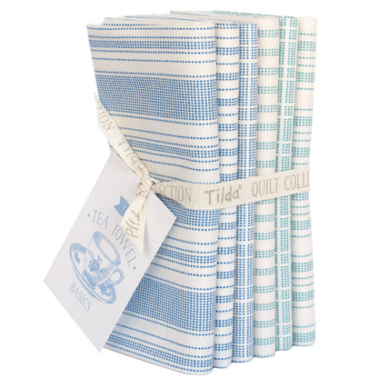 A bundle of six folded quilting fabrics from the Tea Towel Basics Tilda Quilt Collection, featuring blue and white gingham, striped, and checkered patterns, tied with a cream ribbon.
Photo by Tildafabrics.com [additional_image_link]