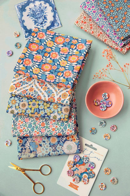 Floral fabrics with scissors and decorative items on a light background.
Photo by Tildafabrics.com [additional_image_link]