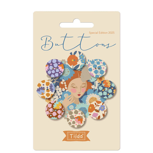 Packaging of Tilda Wallflower Buttons featuring blue and purple fabric covered buttons with floral patterns, name and count indicated on the front.
Photo by Tildafabrics.com [image_link]